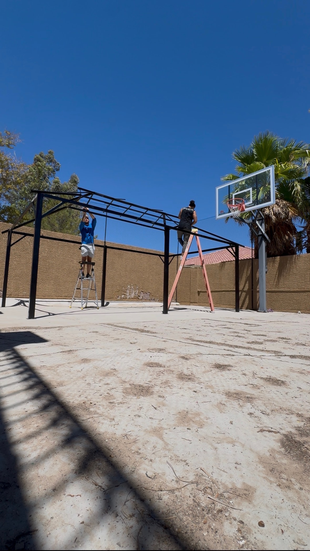 Built It crew assembling a backyard basketball court shade structure in Las Vegas